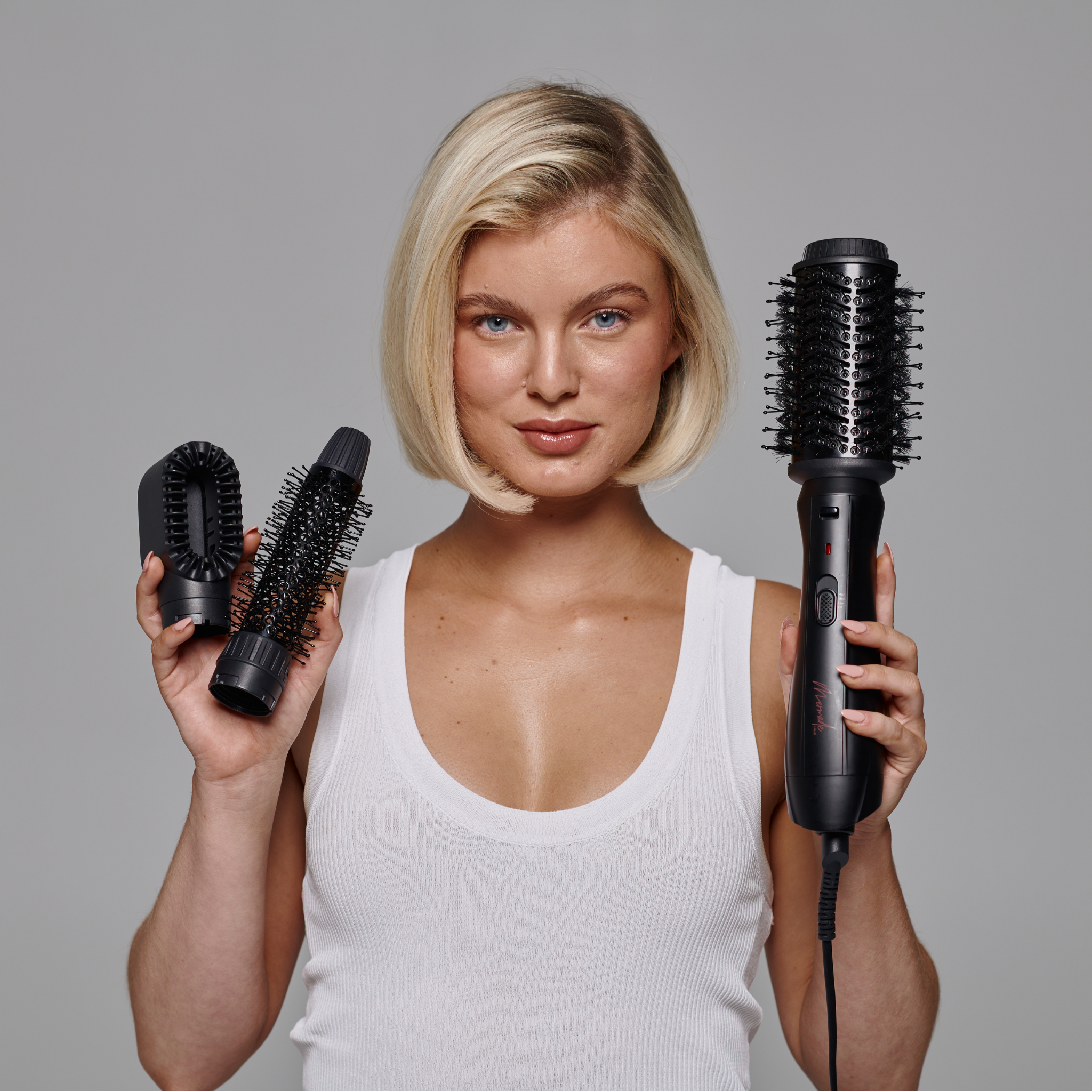 Model with short blonde hair using the Mermade Hair Interchangeable Blow Dry Brush - Sleek Black