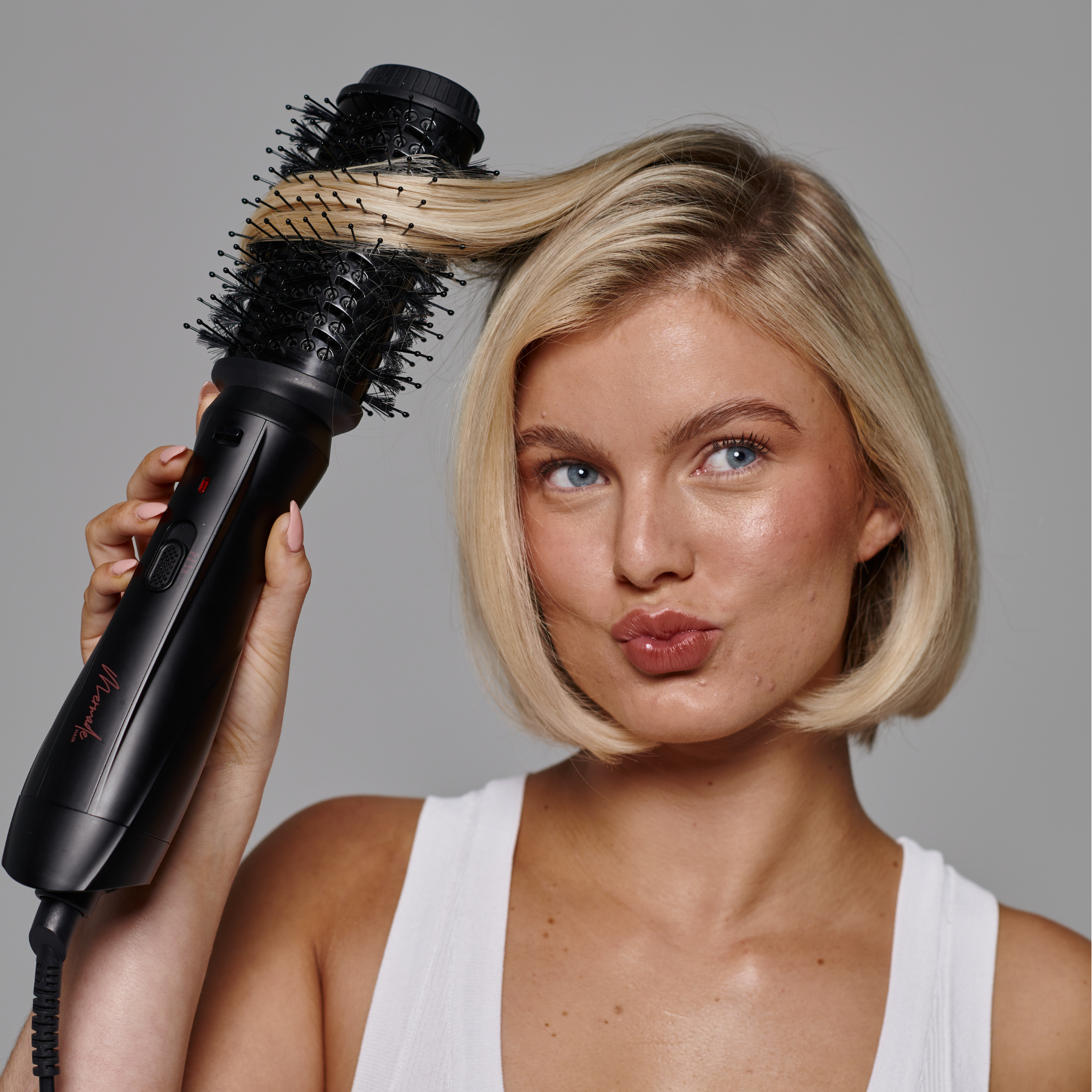 Model with short blonde hair using the Mermade Hair Interchangeable Blow Dry Brush - Sleek Black