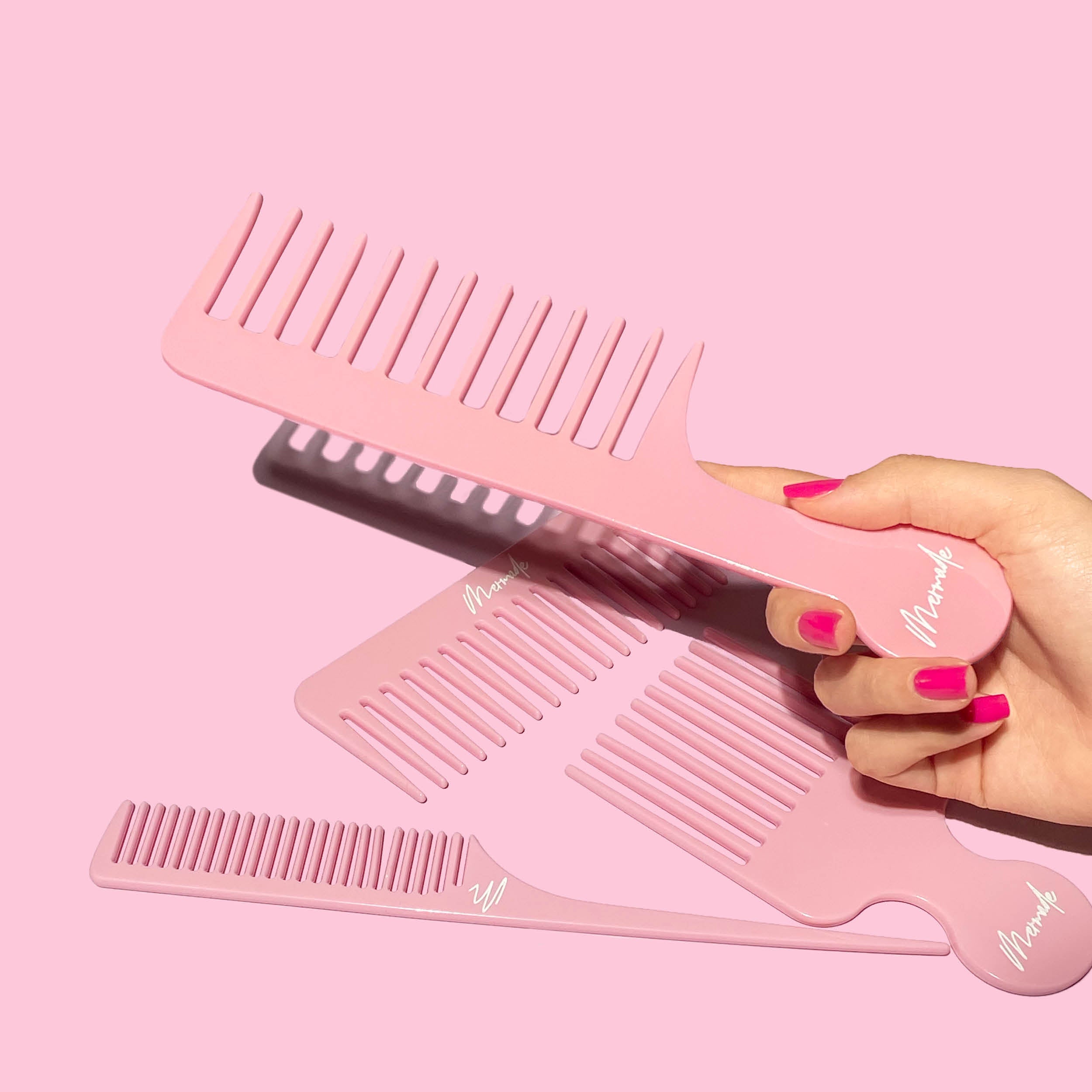 Hand holding Mermade Hair Detangle Comb in Pink